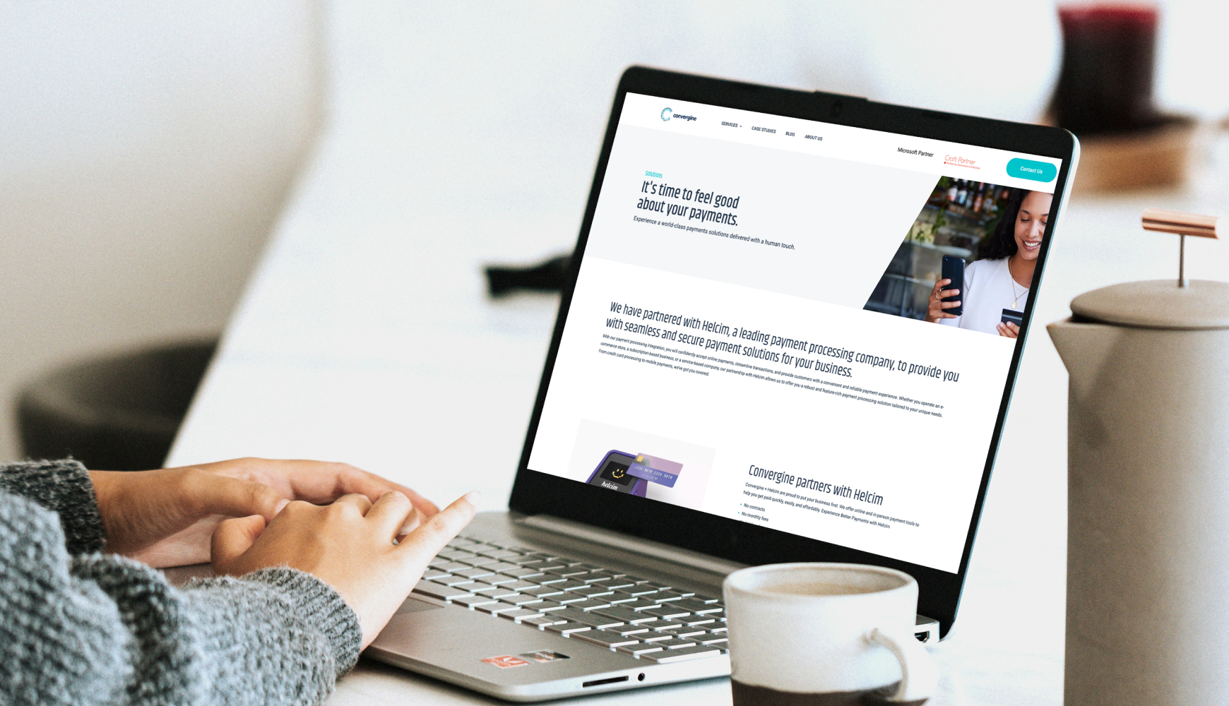 Professional using laptop to research integrated payments solutions with Convergine payment processing platform displayed on screen