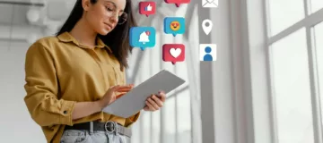 A woman holding a tablet showcasing social media icons, highlighting the integration of social media profiles with website design