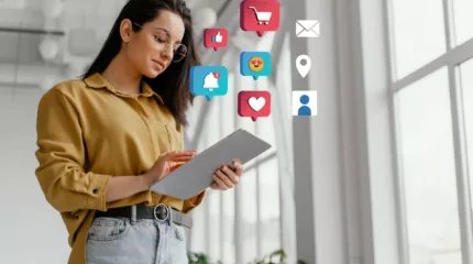 A woman holding a tablet showcasing social media icons, highlighting the integration of social media profiles with website design